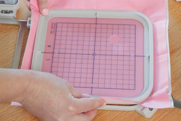 Mise en place facile du tissu dans le cadre de broderie de la Janome MC100e