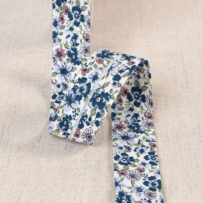 Biais écru fines fleurs bleues et feuillage 20mm /m Biais écru fines fleurs bleues et feuillage 20mm /m